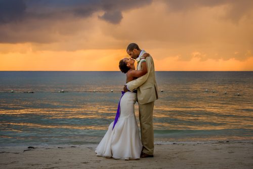 couple kissing in front of sunset on beach in Jamaica