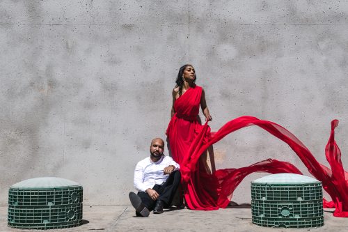 modern editorial fashion couple against concrete wall