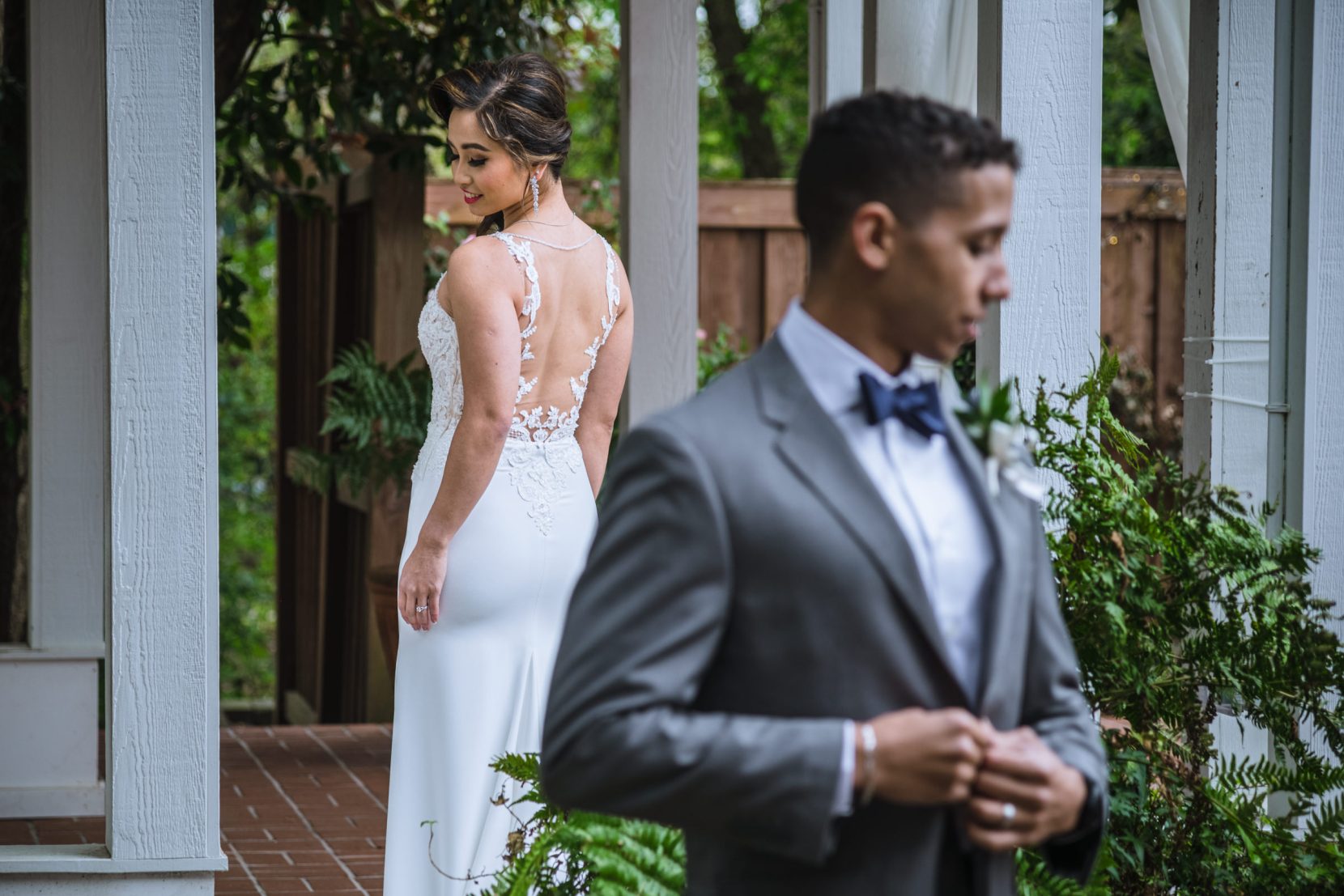 back of bride dress detail groom fastening suit portrait